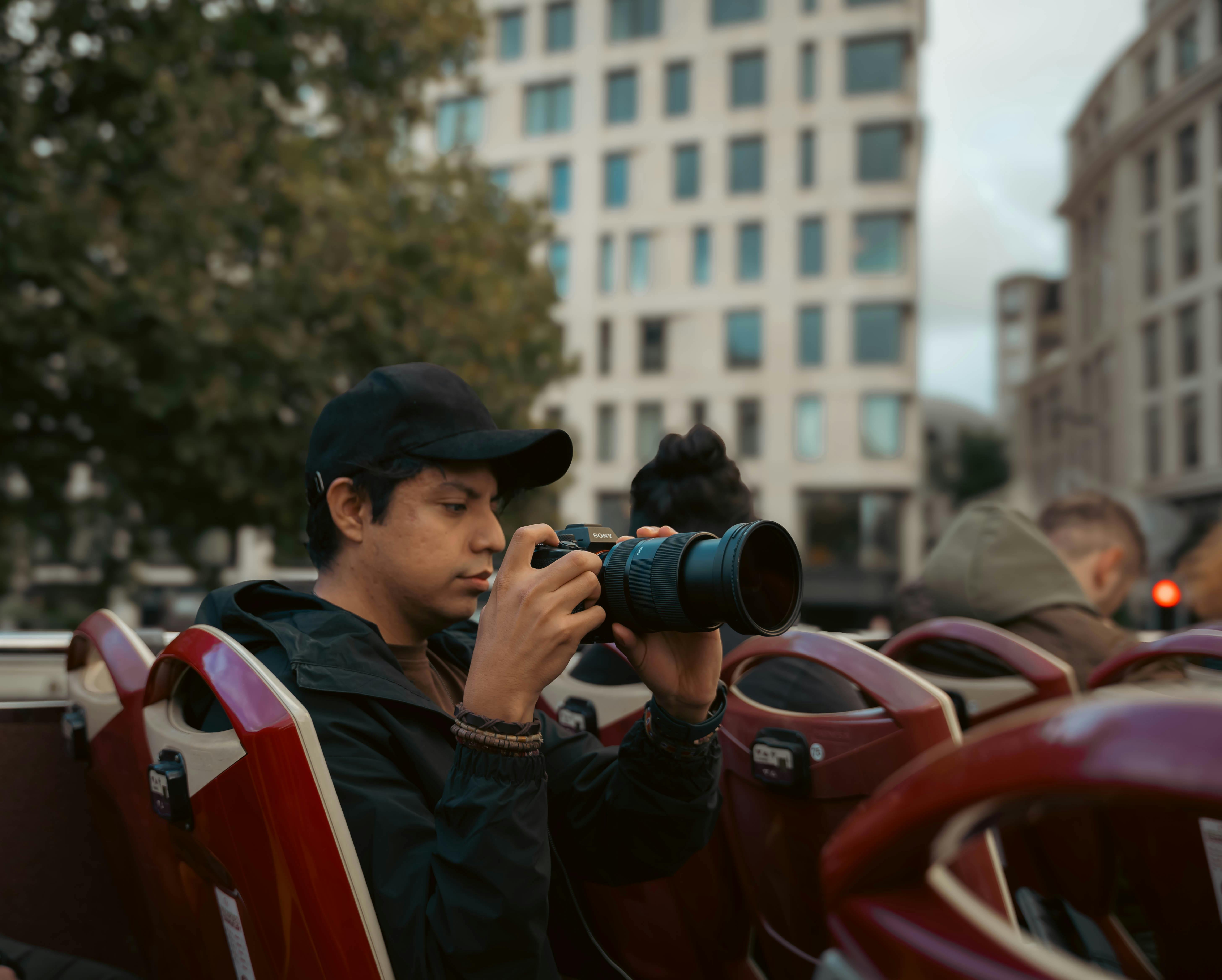 A tourist captures the cityscape of London from an open-top bus, highlighting urban exploration.