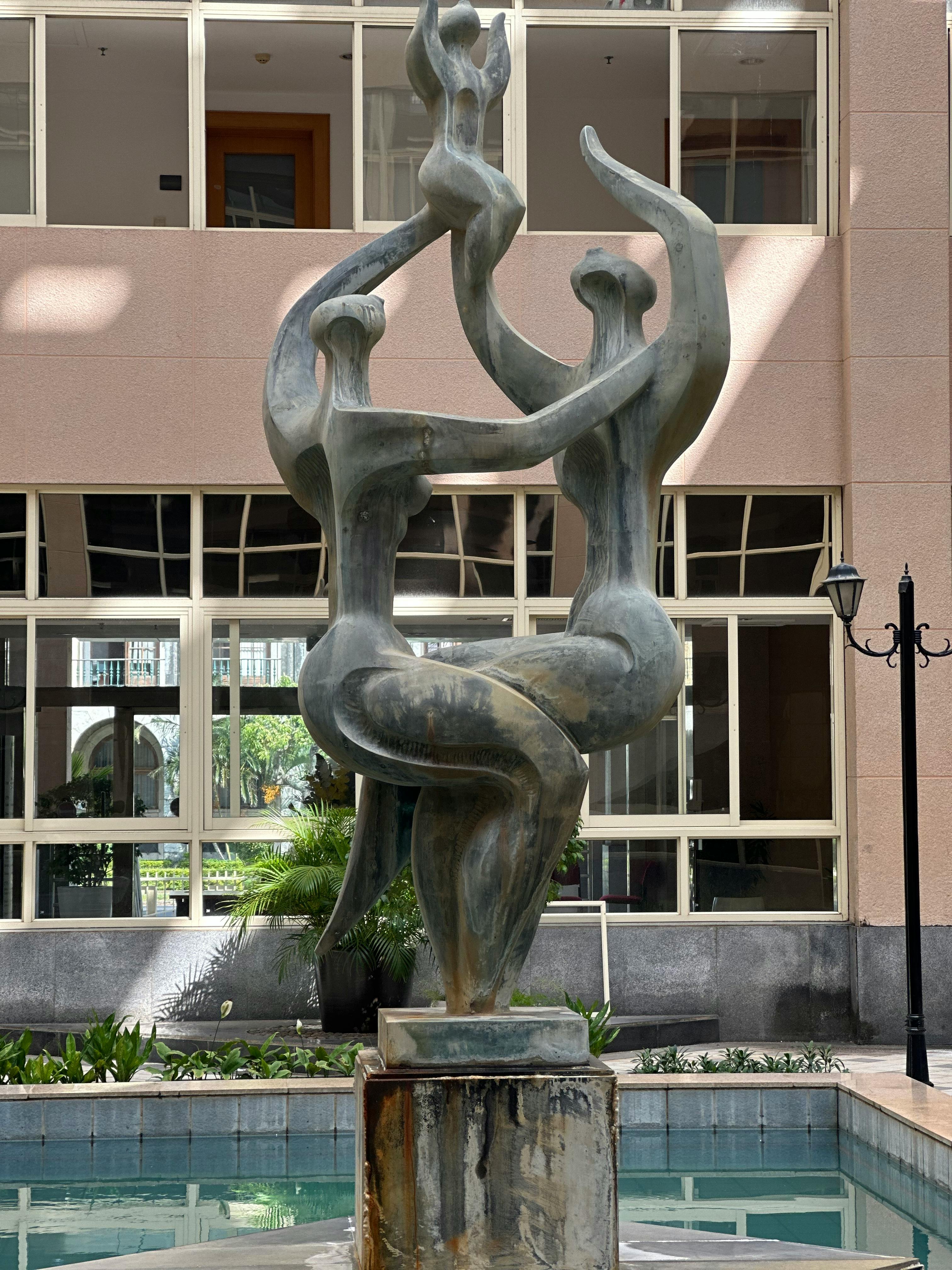 Artistic sculpture in a courtyard of Maputo, Mozambique, showcasing abstract human figures.